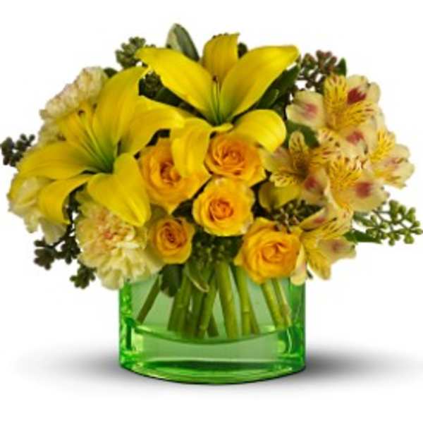 Yellow lilies and roses arranged in a green glass vase