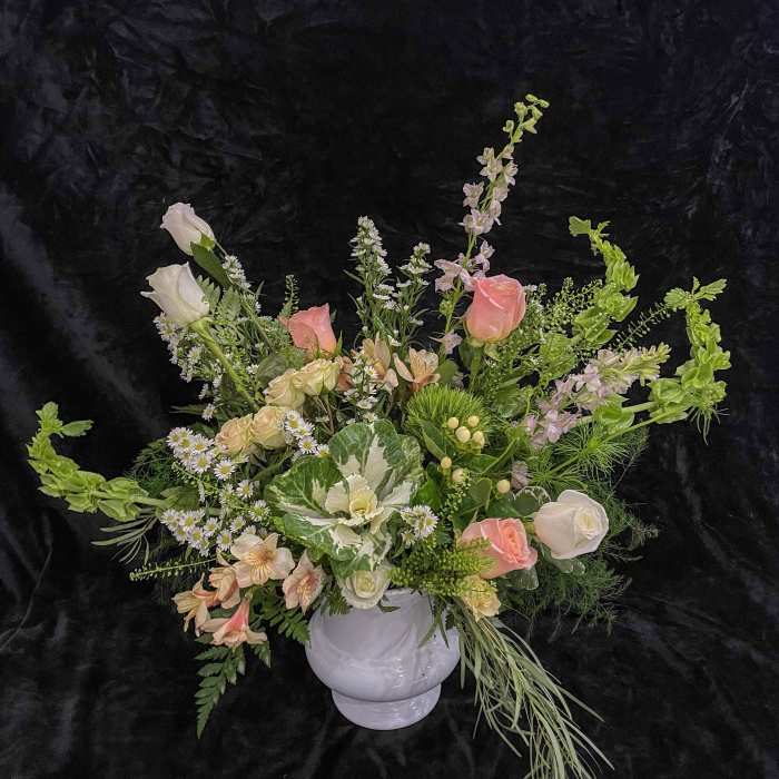 Mixed pastel floral arrangement in a white vase