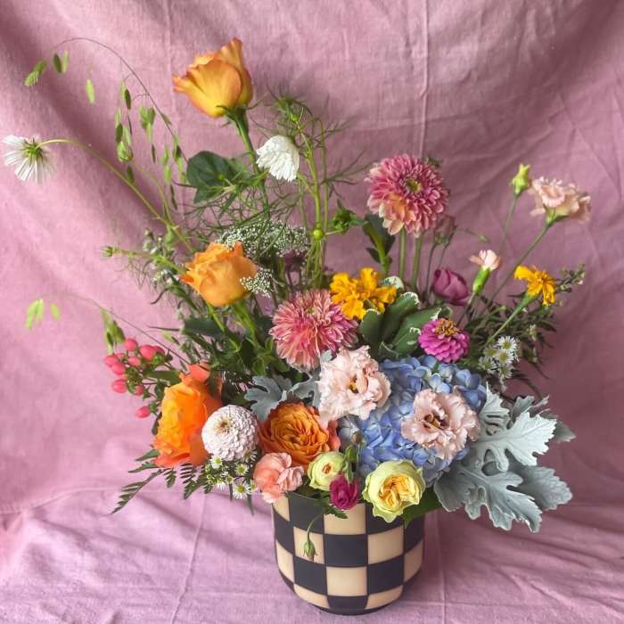 Colorful mixed flower arrangement in a checkered vase