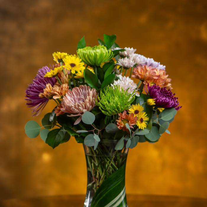 Mixed bouquet of colorful chrysanthemums in a clear glass vase