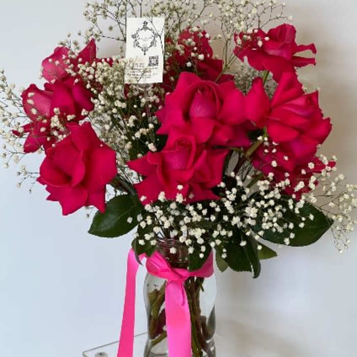 Bouquet of hot pink roses with baby's breath in a glass vase