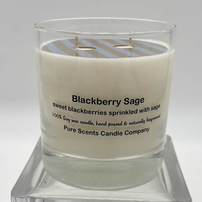 White Blackberry Sage scented candle in a clear glass jar on a glass stand