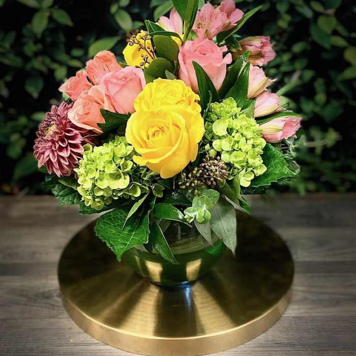 Bouquet of yellow and pink roses in a glass vase