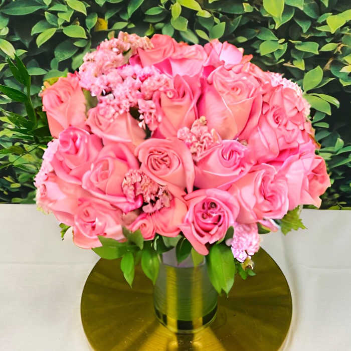 Pink rose bouquet in a gold vase on a round gold base