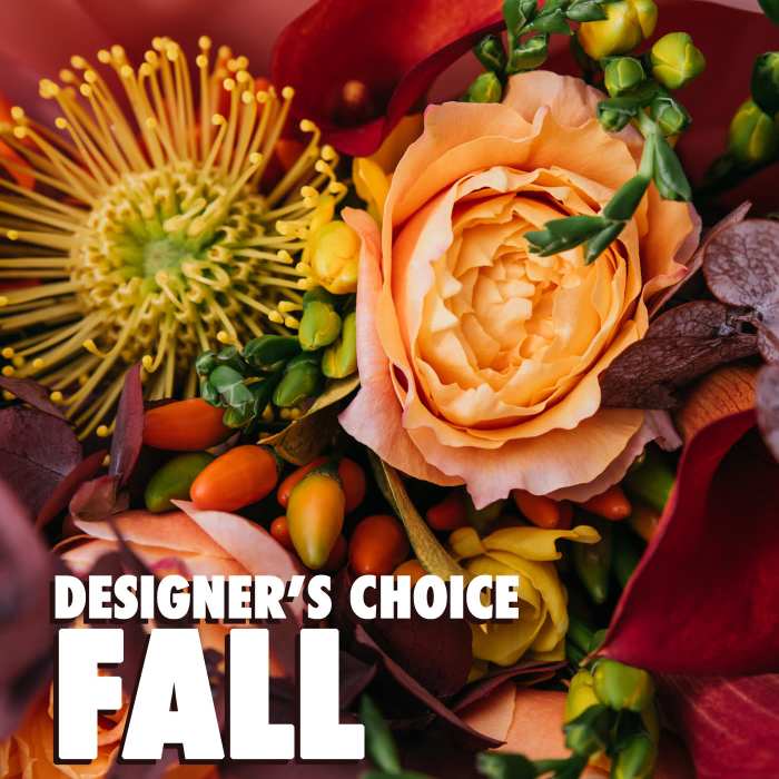 Close-up of a warm-toned fall bouquet with an orange rose and yellow pincushion protea.