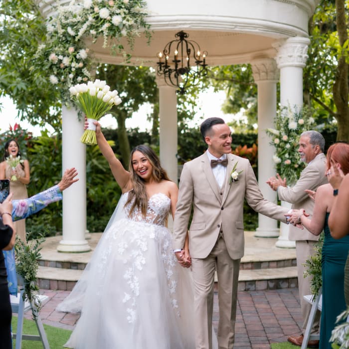 Bride and groom at a wedding ceremony with a white tulip bouquet