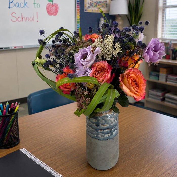 Bouquet of orange and lavender flowers in a blue ceramic vase