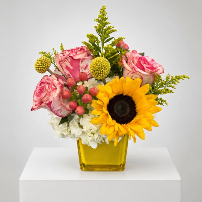 Bouquet of pink roses and a sunflower in a yellow vase