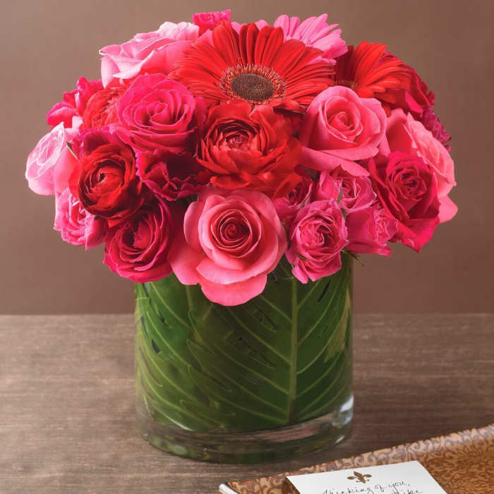 Pink and red roses with gerbera daisies in a glass vase