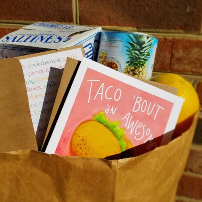 Paper bag filled with greeting cards and packaged snacks
