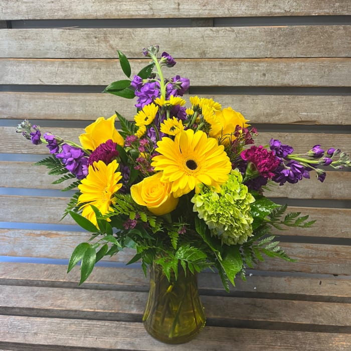 Yellow and purple mixed bouquet in a glass vase