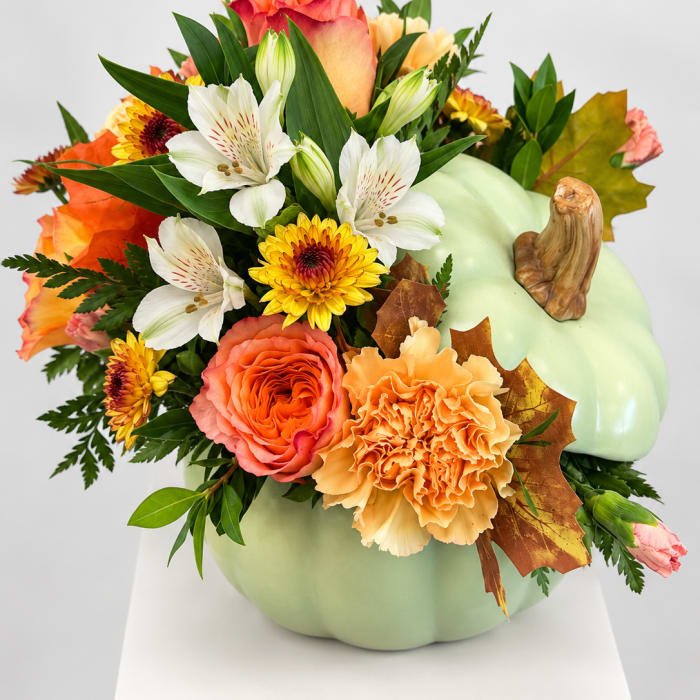 Pumpkin-shaped floral arrangement with orange, white, and yellow blooms