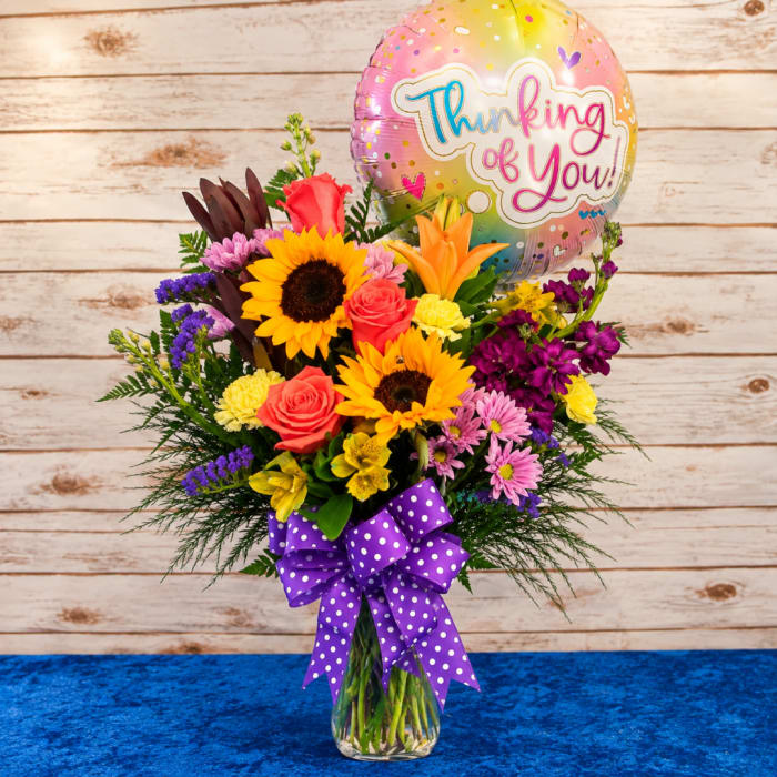 Mixed bouquet in a glass vase with a Thinking of You balloon