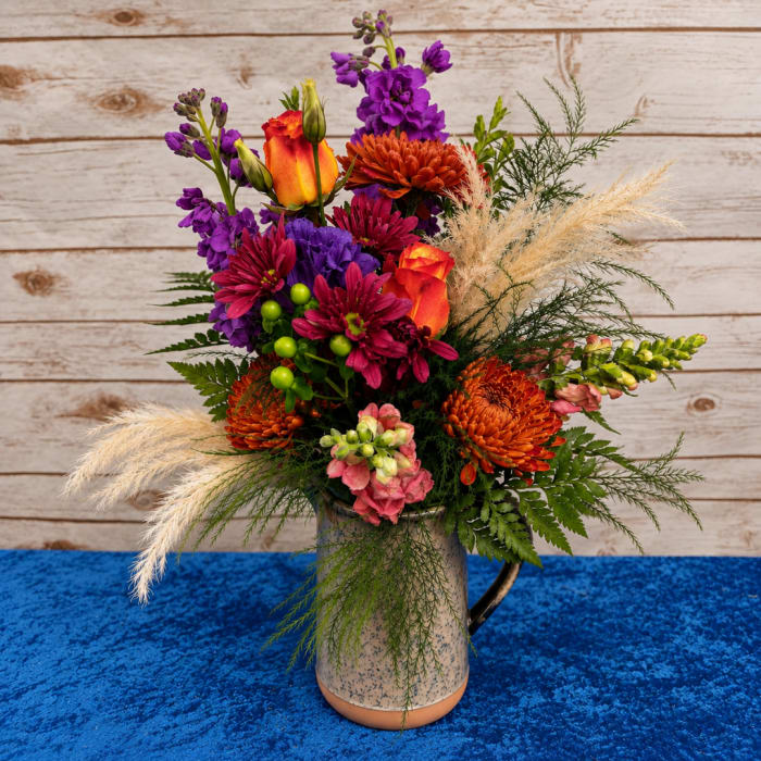 Colorful mixed bouquet in a speckled mug-style vase