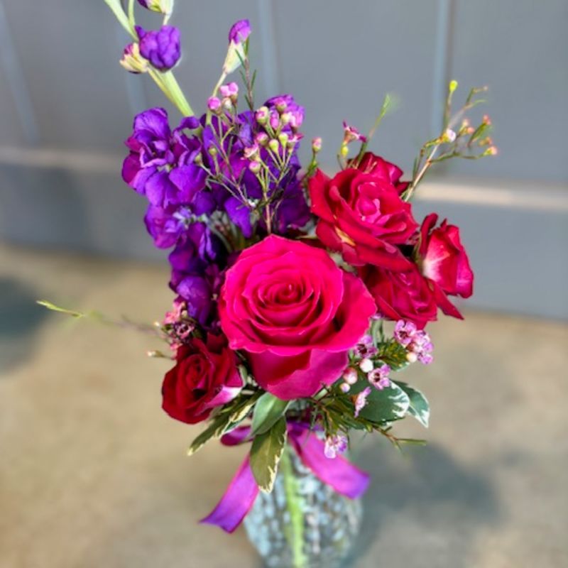 Bouquet of pink and purple roses in a glass vase