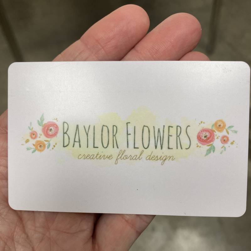 A business card reading Baylor Flowers with small floral illustrations