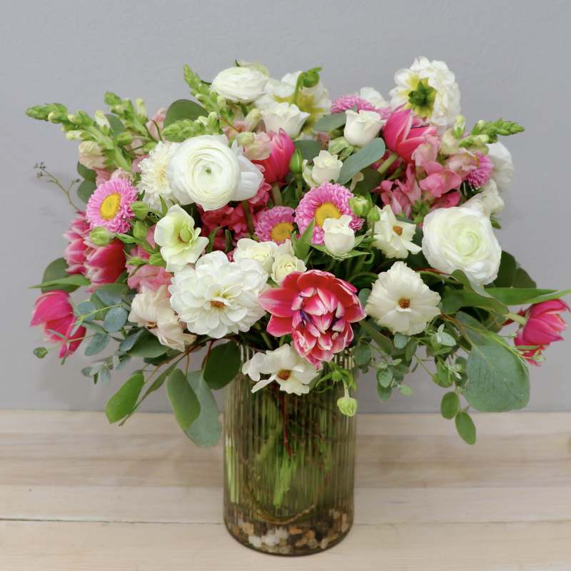 Mixed pink and white flowers arranged in a glass vase