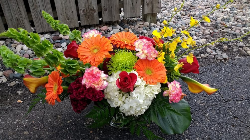 Orange gerber Daisy, roses, dfuji, carnations, bells of Ireland, orchids, hydrangea