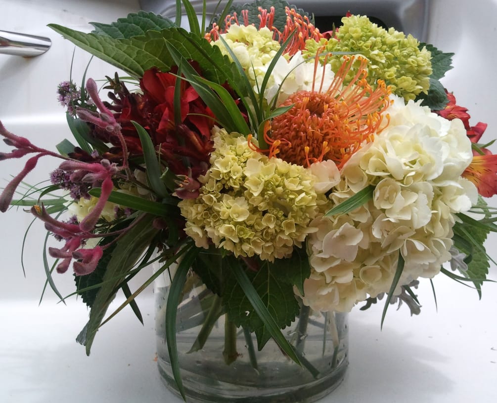 large low cylinder filled with white and miniature green hydrangeas, sunset orange