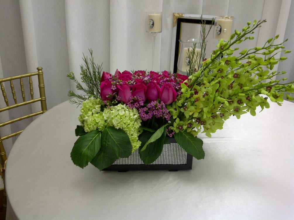 Striking combination of vibrant roses and green dendrobium orchids with hydrangea and