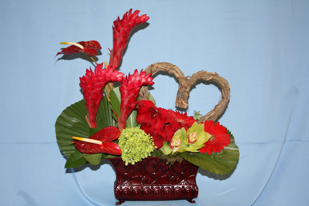 modern arrangement includes tropical flowers- ginger, anthuriums, big tropical foliage, roses, cymbidium