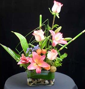 This expressive arrangement was created with Asiatic lilies, blush roses, and a