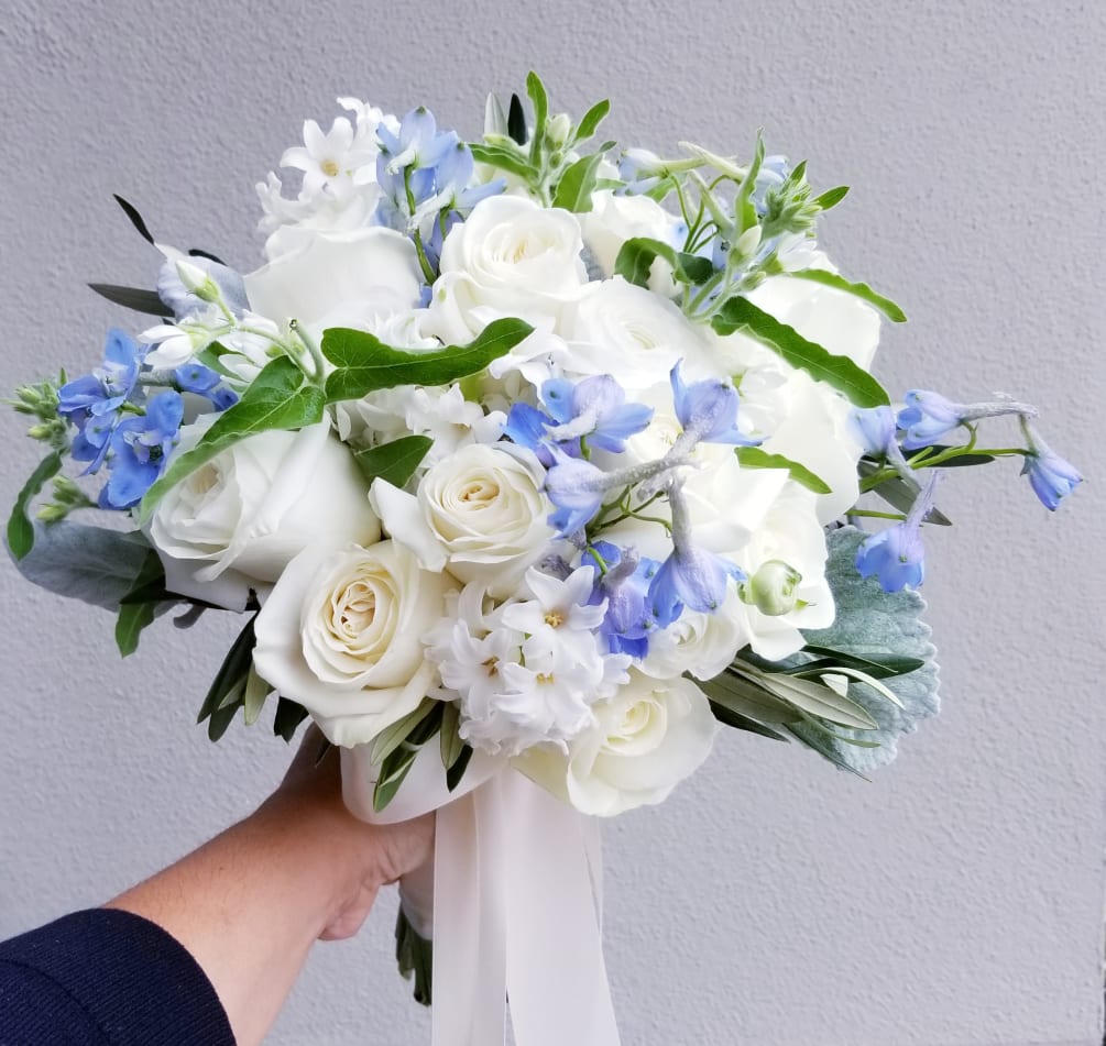 Lovely wedding bouquet composed of white roses, rananculus, hyancinth and a touch