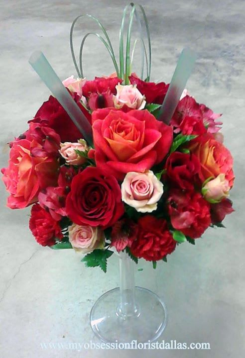 Fresh floral arrangement of roses and spray roses in margarita shaped container