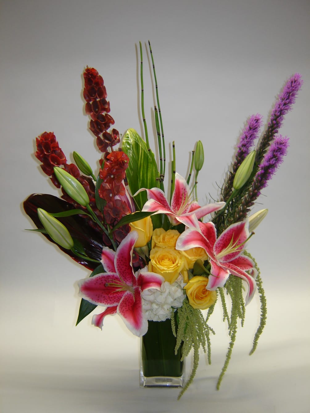 Red Bells of Ireland, liatris, stargazer lilies, yellow roses and hydrangea will
