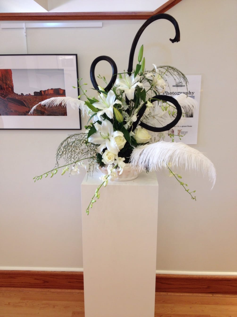 A dramatic arrangement of ostrich feathers, white lilies, roses, genestra, dendrobium orchids