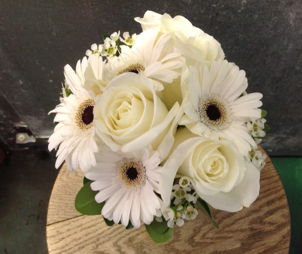 A lovely small bouquet of all white flowers, including Roses, Gerbera Daisies
