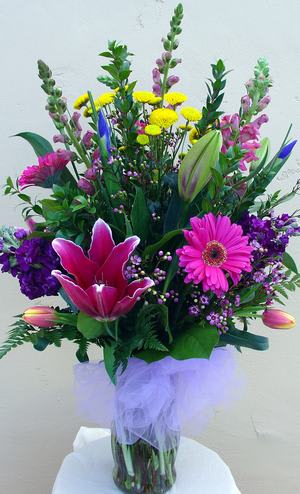 Bright mix with fragrant lillies in standard vase. 