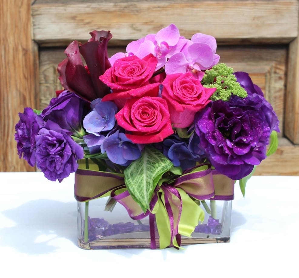 Desk sized arrangement of Roses, Hydrangeas, Callas and Orchids and glass vase.