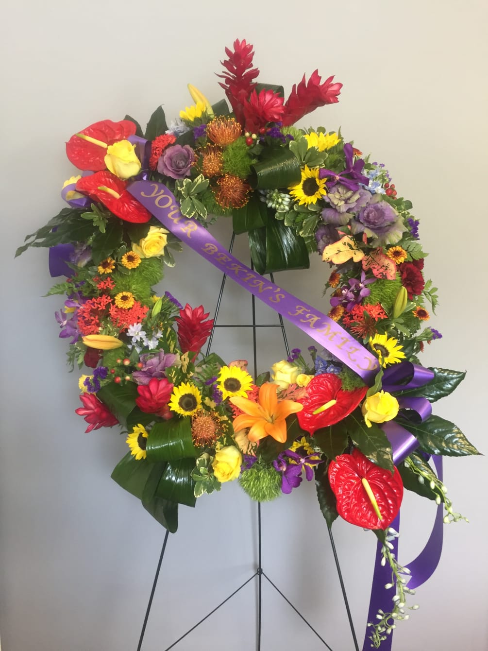 Tropical Sympathy Wreath is made with some anthuriums, ginger, pincushions, lilies, sunflowers