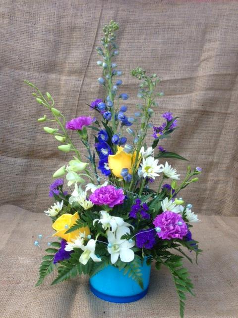Beautiful array of dendrobium orchids, yellow roses, blue delphinium and more!