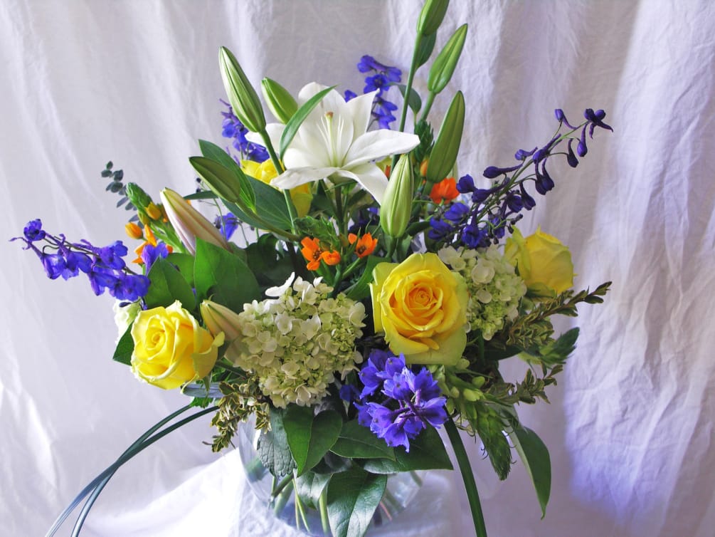 Assorted spring flowers in a clear glass vase 