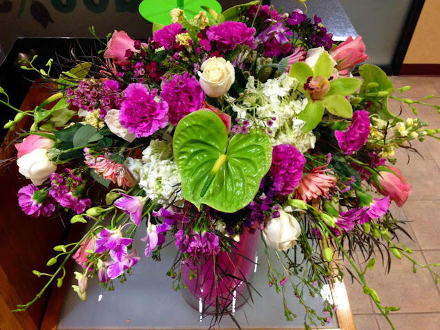Purple Love Passion with Lily pods, orchids, carnations, lisianthus, waxflower and roses.