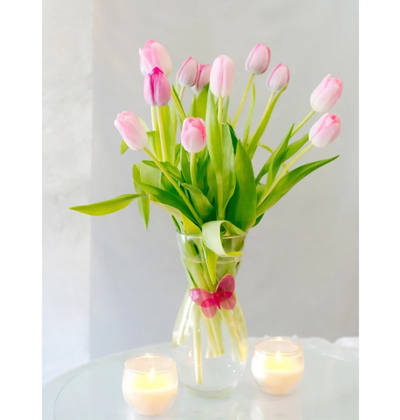 A dozen pink tulips in a clear vase