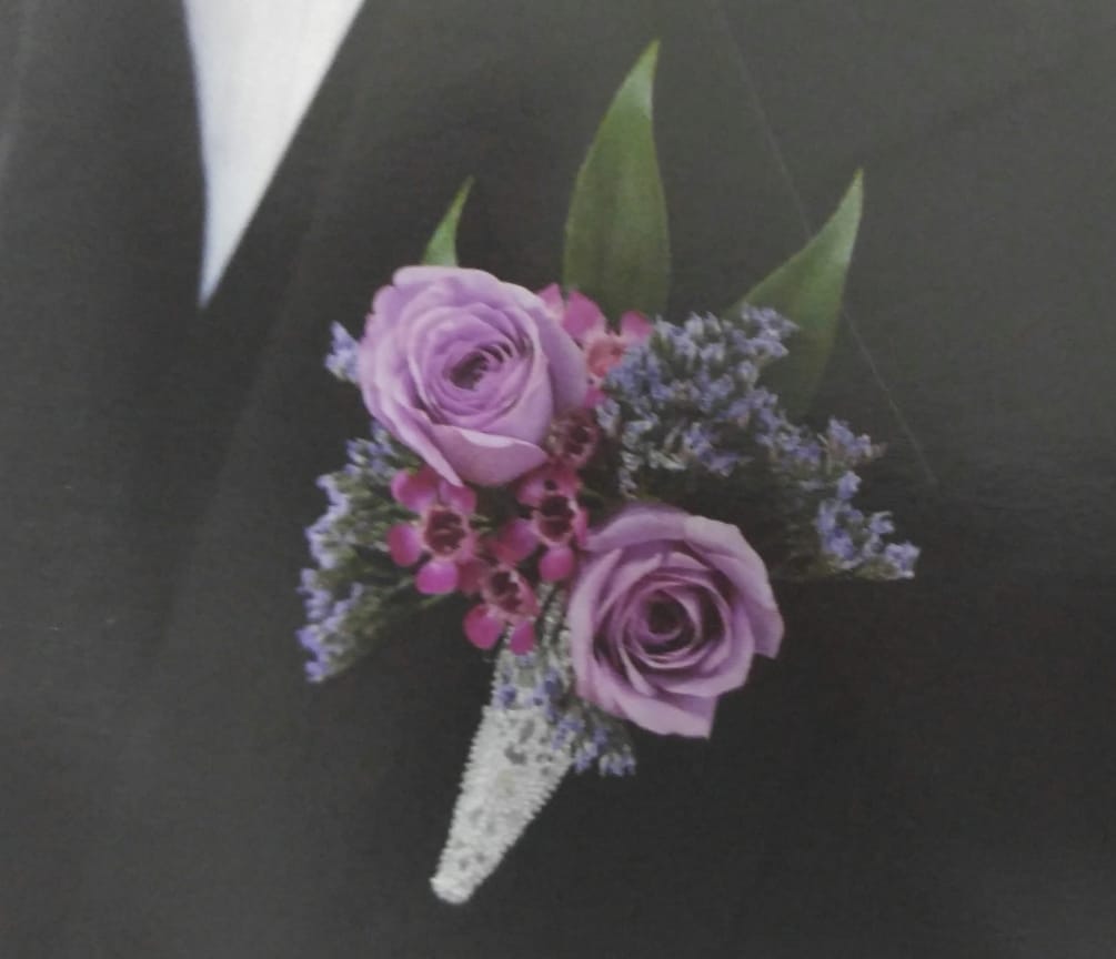 lavender rose complimented by wax flower,statice and lace wrap. 