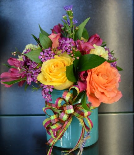 Different Color Roses, Alstro, Waxflower and more in this magical arrangement!