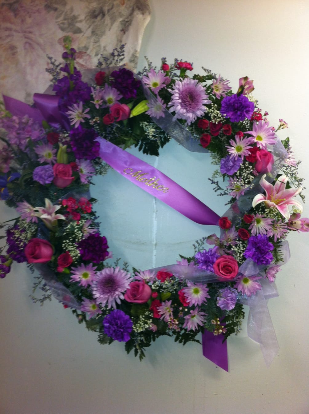 A beautiful fresh flower wreath in shades of purples for a Funeral