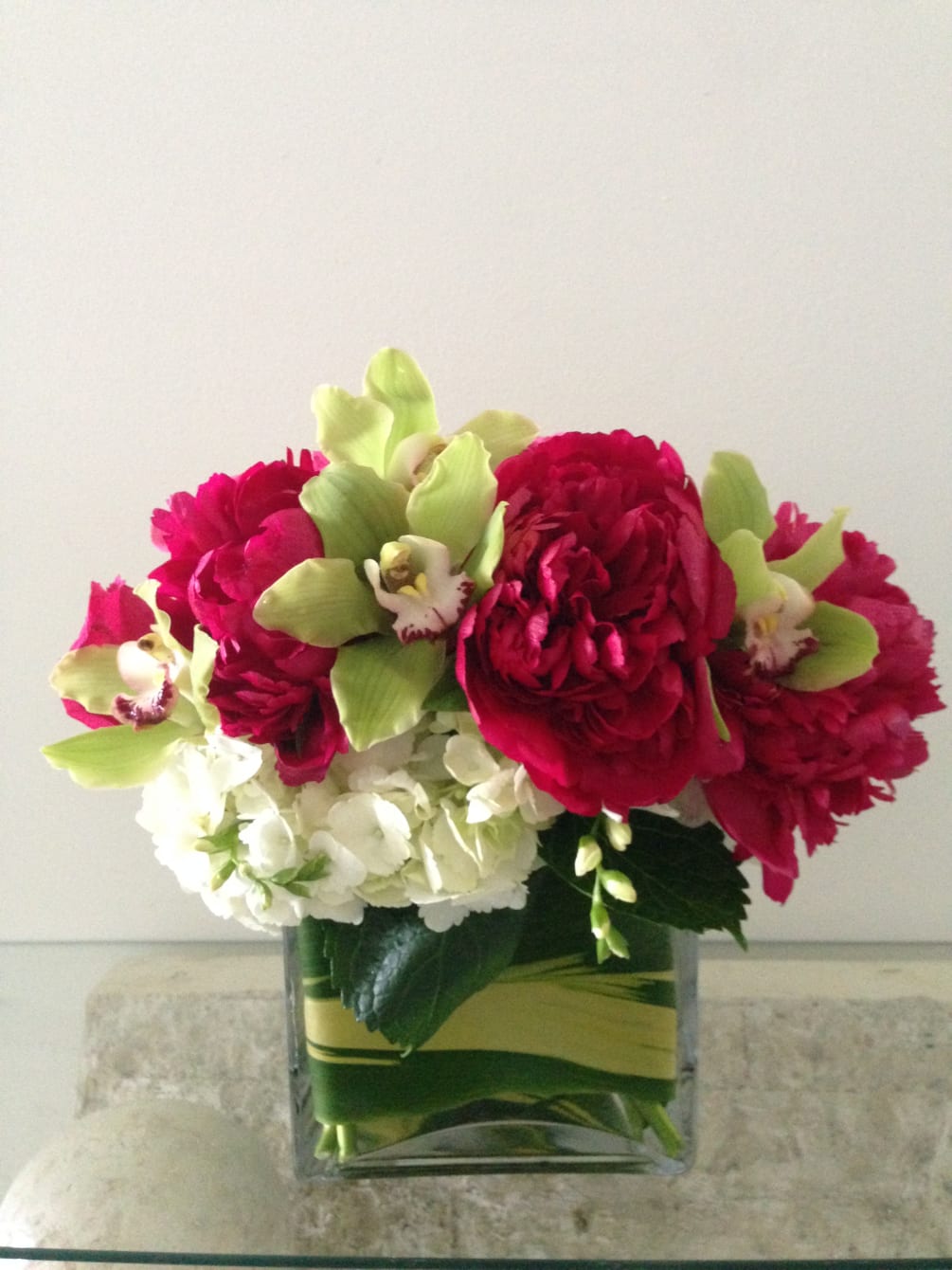 A lush bouquet of peonies, cymbidium orchids, and much more, designed in