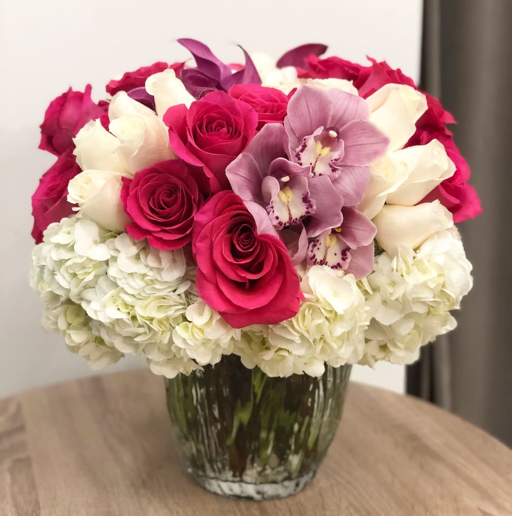 White hydrangeas, hot pink roses, light pink cymbidium orchid blooms arranged in