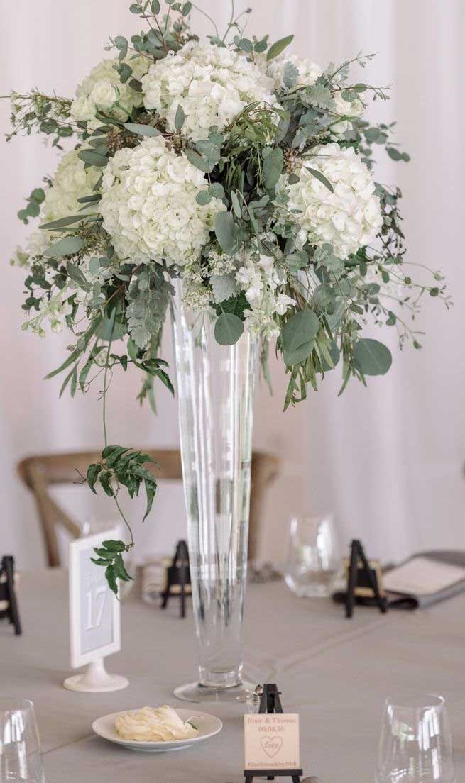 White Hydrangeas, stock, eucalyptus and more fill this tall and gorgeous table