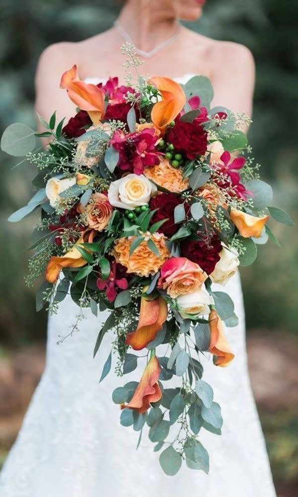 Orange Calla lily, hydrangeas, roses, seeded eucalyptus, and more fill this lovely
