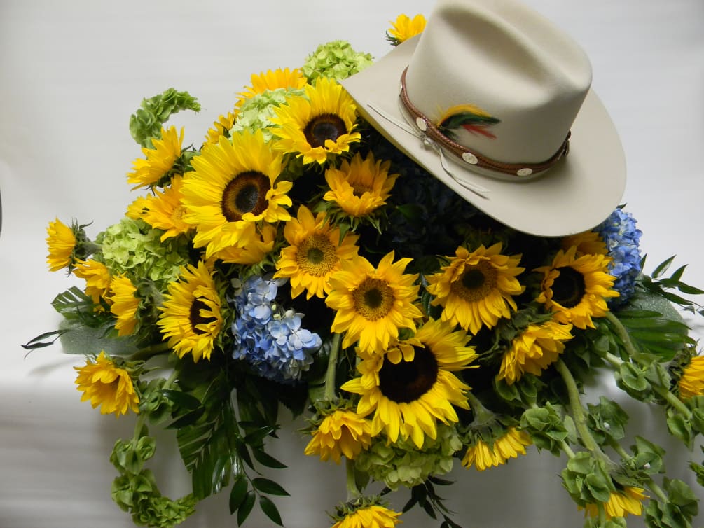 Casket spray of sunflowers, accented with blue hydrangea    