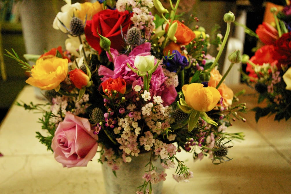 mix bouquet of small flowers in a ceramic container