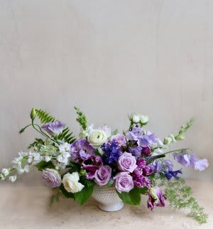 This arrangement with blooms in hues of lavender and plum is a