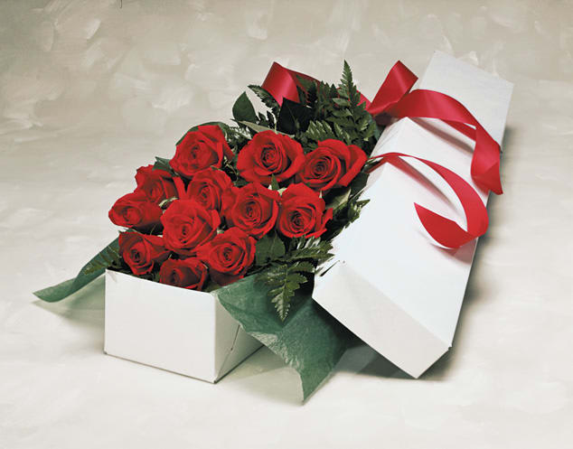 Dozen roses arranged and water tubed in long box with greens and