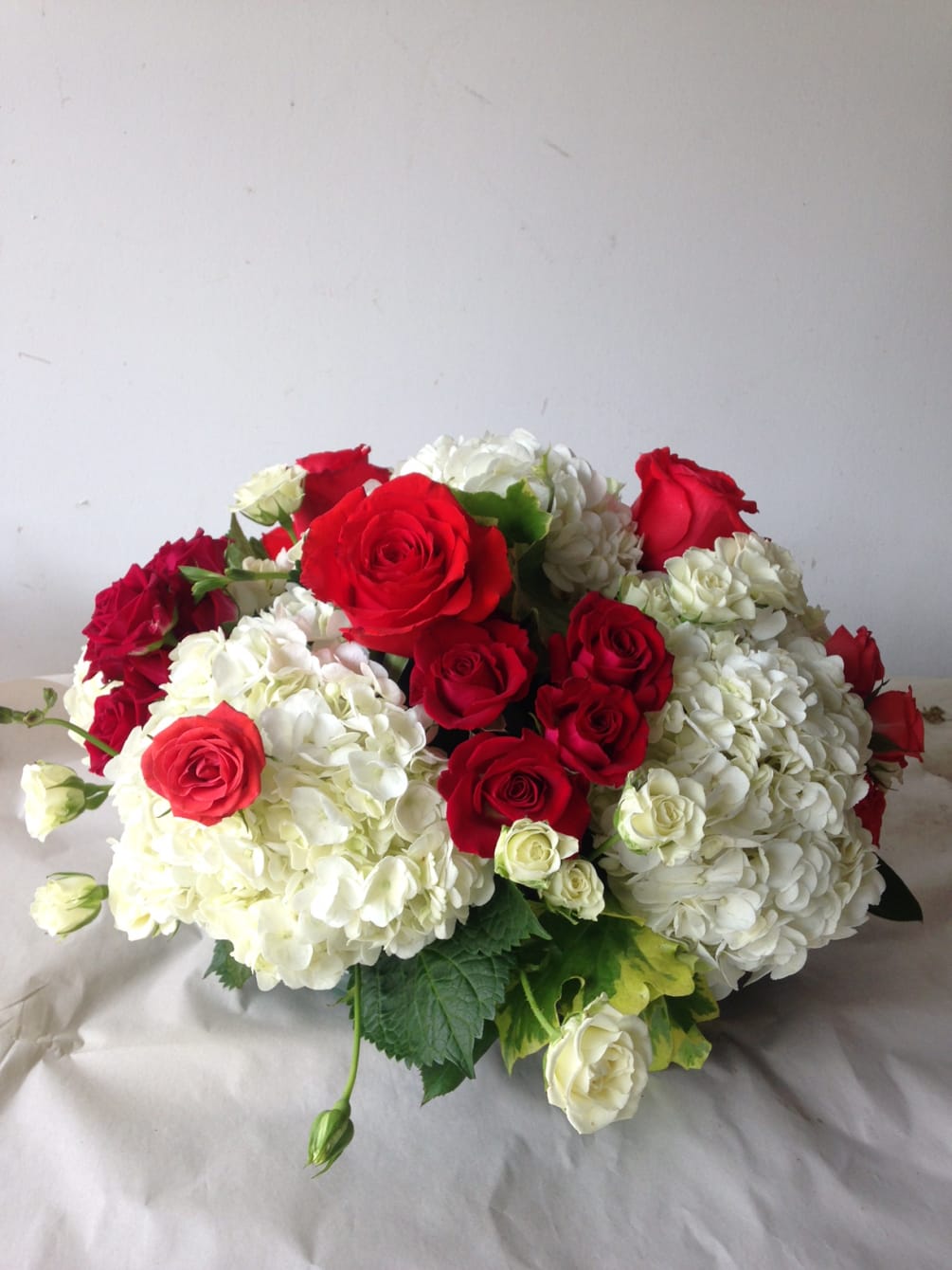 Fluffy white Hydrangeas with sweet red roses and touch of scented geranium